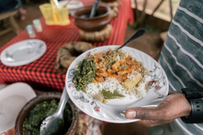 Close-up of a man holding a traditio<em></em>nal African dish 