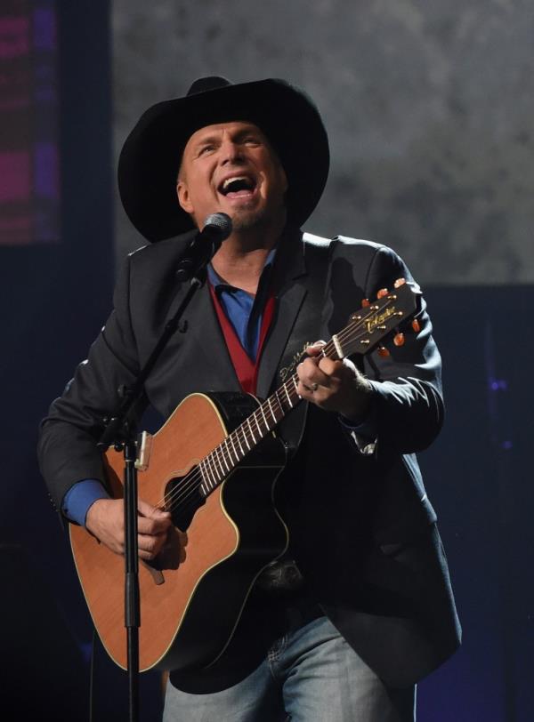 Garth Brooks in a cowboy hat playing guitar at the Musicians Hall of Fame 2016 Induction Ceremony in Nashville, Tennessee