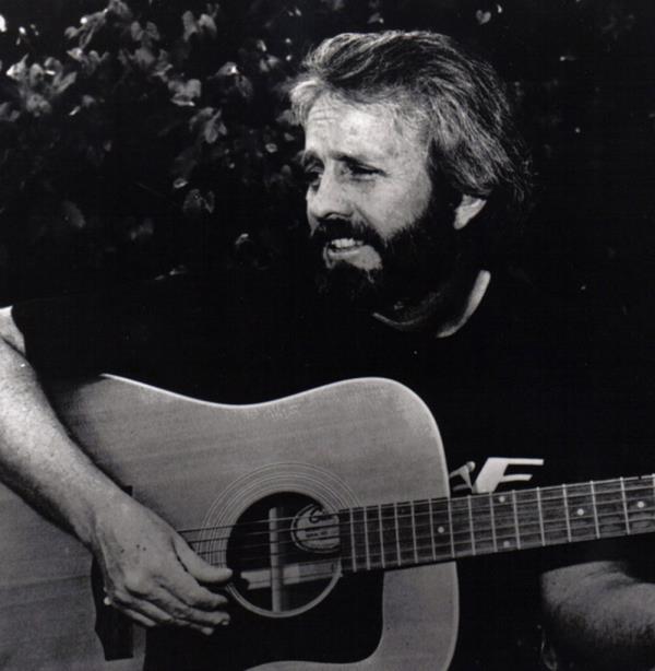 A man playing a guitar, Larry Bastian, who passed away at 90