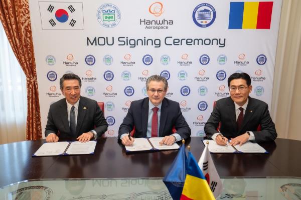 Bae Jin-kyu (R), chief of Hanwha Aerospace Romania, and Mihnea Costoiu (C), rector of the University of Science and Technology Politehnica Bucharest, pose for a photo during a signing ceremony in Bucharest on April 16, 2025, in this photo provided by the Korean company. (PHOTO NOT FOR SALE) (Yonhap)