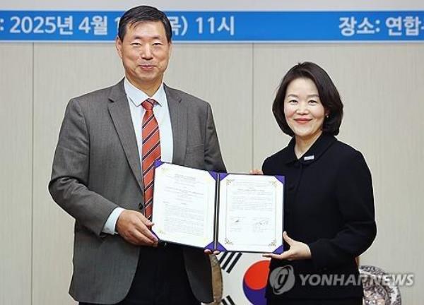 Yo<em></em>nhap News Agency President and CEO Hwang Dae-il (L) and Kim Sae-ryeo, representative of the United Nations High Commissio<em></em>ner for Refugees Korea, pose for a photo after signing a memorandum of understanding at Yonhap's headquarters in Seoul on April 17, 2025. (Yonhap)