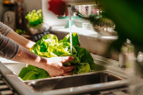 Washing greens can remove pesticides, but it's not been proven to be effective in removing pathogens.